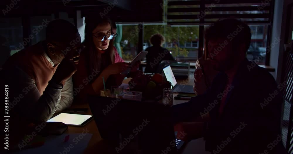 A multiethnic team of business professionals concentrates on a project during late-night hours in an office, showcasing dedication and collaborative teamwork. A multiethnic team of business professionals concentrates on a project during late-night hours in an office, showcasing dedication and collaborative teamwork.