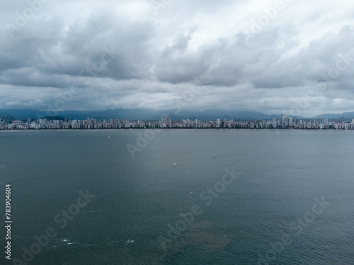 large coastal city seen from the sea with building and many clouds