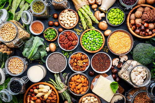 Vegan food background. Plant protein., vegetarian nutrition sources. Healthy eating, diet ingredients: legumes, beans, lentils, nuts, soy milk, tofu, cereals, seeds and sprouts. Top view, black table © 5ph