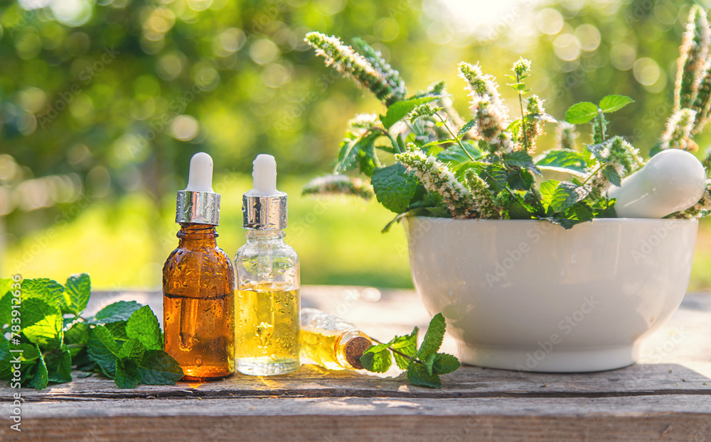 Peppermint essential oil in a bottle. selective focus. Peppermint essential oil in a bottle. selective focus.