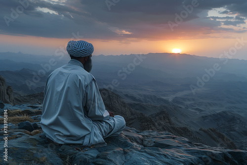 Man Sitting on Cliff Overlooking Valley