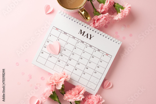 Celebrating mother's day: flat lay of may calendar with carnations and coffee on a pink background photo