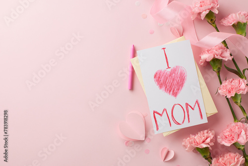 Mother's day affection: top view of handmade card and carnations on a soft pink background
