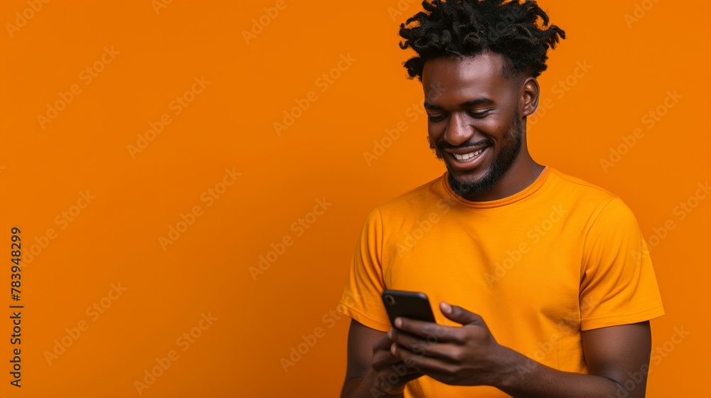 Isolated young man using mobile smart phone on a orange background - Millennial holding cellphone - People and technology concept Isolated young man using mobile smart phone on a orange background - Millennial holding cellphone - People and technology concept