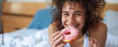 Smiling woman with a pink doughnut. Playful and cozy atmosphere. Sweet moments and happiness concept