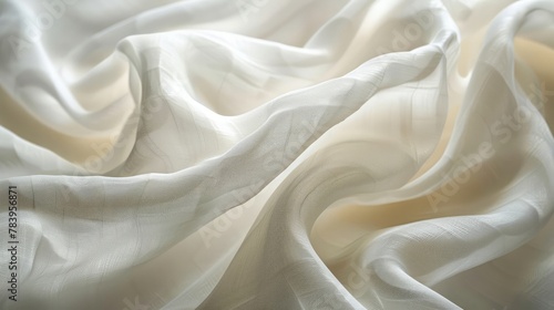 Close-up image of elegant white drapery, with light creating soft shadows and highlights on the fabric folds.