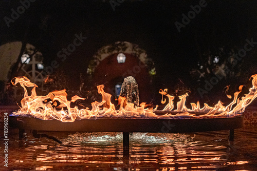 Night photograph of A ring of fire over a fountain of water in the center of a plaza in Mexico City, Mexico CDMX