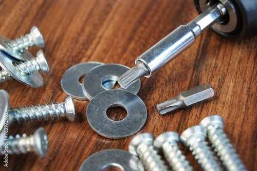 Working environment. Screws for concrete and metal washers on a wooden table. 