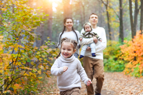 Smiling family with two children outdoors © Dasha Petrenko