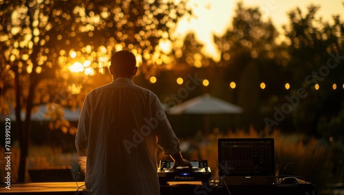 Silhouette of a DJ mixing music outdoors with a beautiful sunset in the background, showcasing a summer music festival