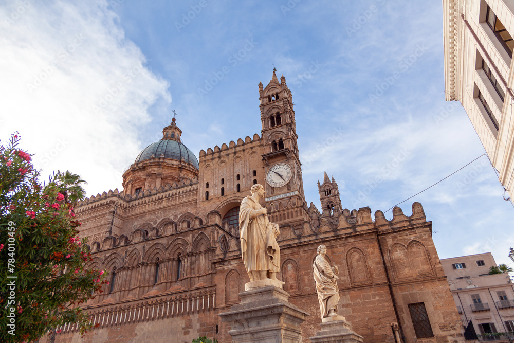 Facade of the historical Palermo Cathedral, framed by clear skies and adorned with sculptures, in Sicily, Italy
