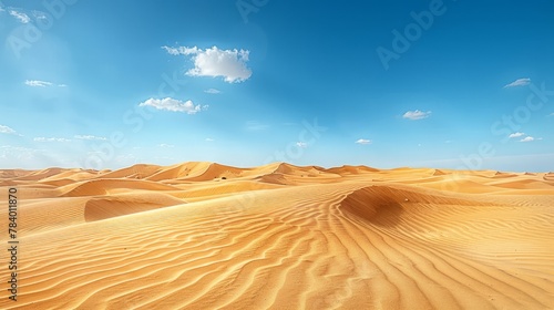   A group of sand dunes beneath a blue sky  adorned with a few white clouds scattered in the midst