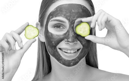 Beautiful smiling woman with clear skin holds a cucumber near her face. She applied the mask to her face. Cosmetological skin care
