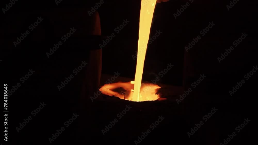 Molten metal flows from furnace in steel casting process. Industrial workers oversee smelting, pour liquid iron into molds at foundry. Manufacturing stages of metalwork, heat-resistant equipment use. Molten metal flows from furnace in steel casting process. Industrial workers oversee smelting, pour liquid iron into molds at foundry. Manufacturing stages of metalwork, heat-resistant equipment use.
