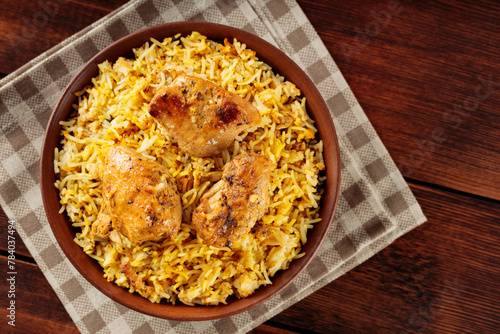 Pakistani and Indian Chicken Biryani Rice in Clay Bowl on Wooden Boards