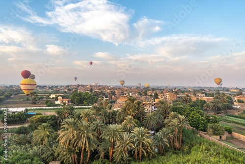 Luxor, Egypt - October 27, 2022. Group of balloons flying over Al Biirat village around Luxor during the sunrise.