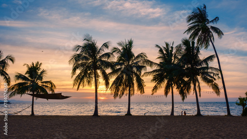 White tropical beach during sunset in Pattaya Najomtien. Palm trees at the beach during sunset photo