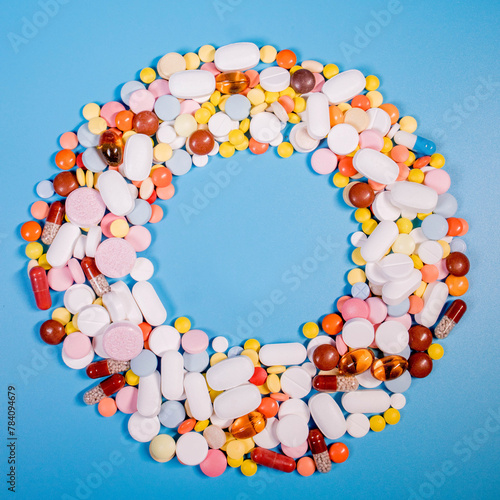 Frame with colorful pills and capsules on a blue background. Place for text