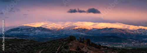 Panoramic view of Sierra Nevada (Granada, Spain) at sunset after a heavy snowfall in spring photo