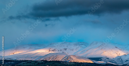 Panoramic view of Sierra Nevada (Granada, Spain) at sunset after a heavy snowfall in spring