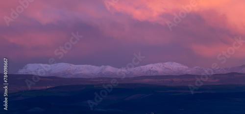 Landscape of distant snowy mountains at sunset © Miguel Ángel RM
