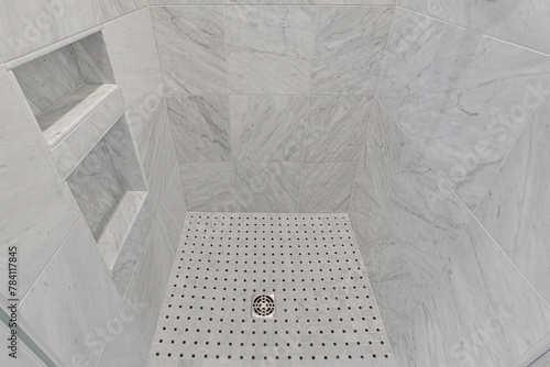 Luxurious Walk-In Shower, Fully Tiled with Marble, and A Patterned Tile Floor, Built in Shelves