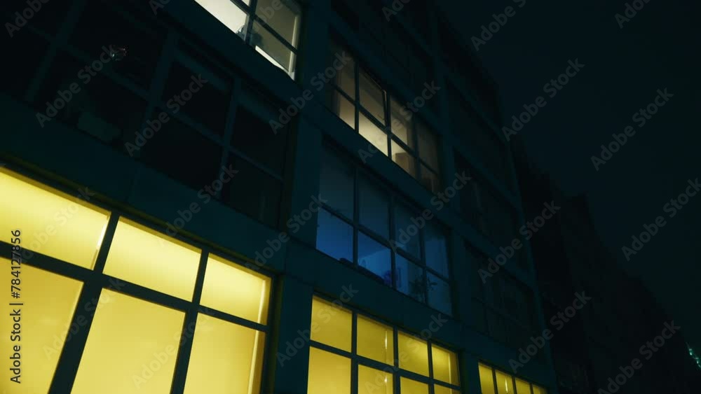 a building with a lot of windows is lit up at night. Scary halloween establishing shot a building with a lot of windows is lit up at night. Scary halloween establishing shot
