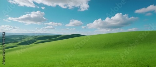 Amazing panoramic of beautiful green grass field on hills and blue sky with clouds. Spring summer landscape background concept.
