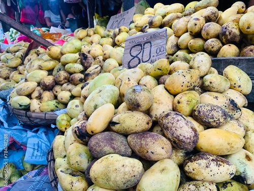 An overripe pile of Mangoes is on display and the price tag is P80 Philippine pesos in value per kilo. photo