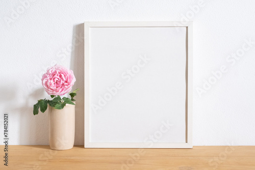 mock up frame photo with pink rose on table