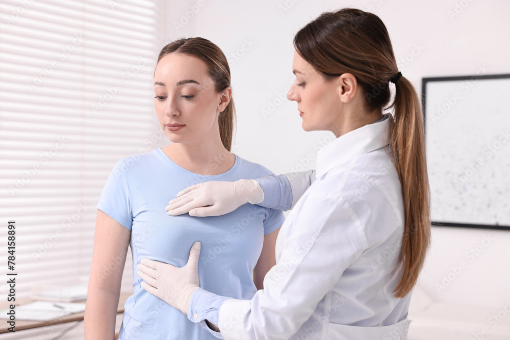 Mammologist checking young woman's breast in hospital Mammologist checking young woman's breast in hospital