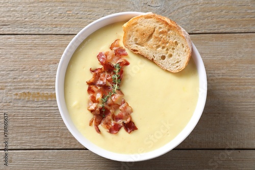 Tasty potato soup with bacon and crouton in bowl on wooden table, top view