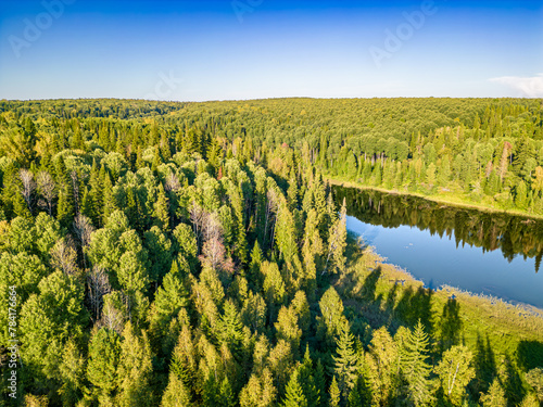 the mirror surface of the lake located among the endless taiga, view from above