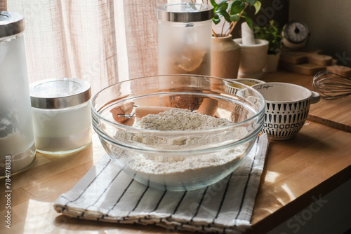 The flour in the glass bowl on the decorative kitchen counter top for baking and cooking pastry concept.