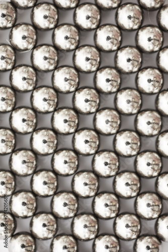 magnetic ball bearing tiling in perfect hexagonal grid. Metal balls close up. Balls of neodymium (magnets).