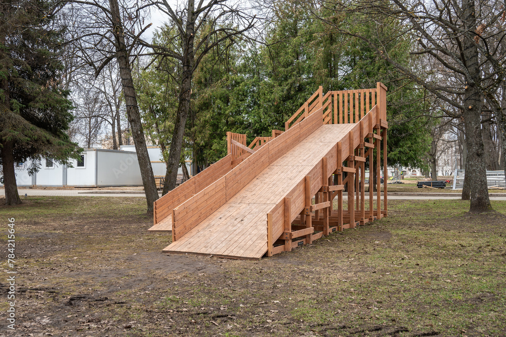 Children playground in the public park. New wooden slide for sliding. Children playground in the public park. New wooden slide for sliding.