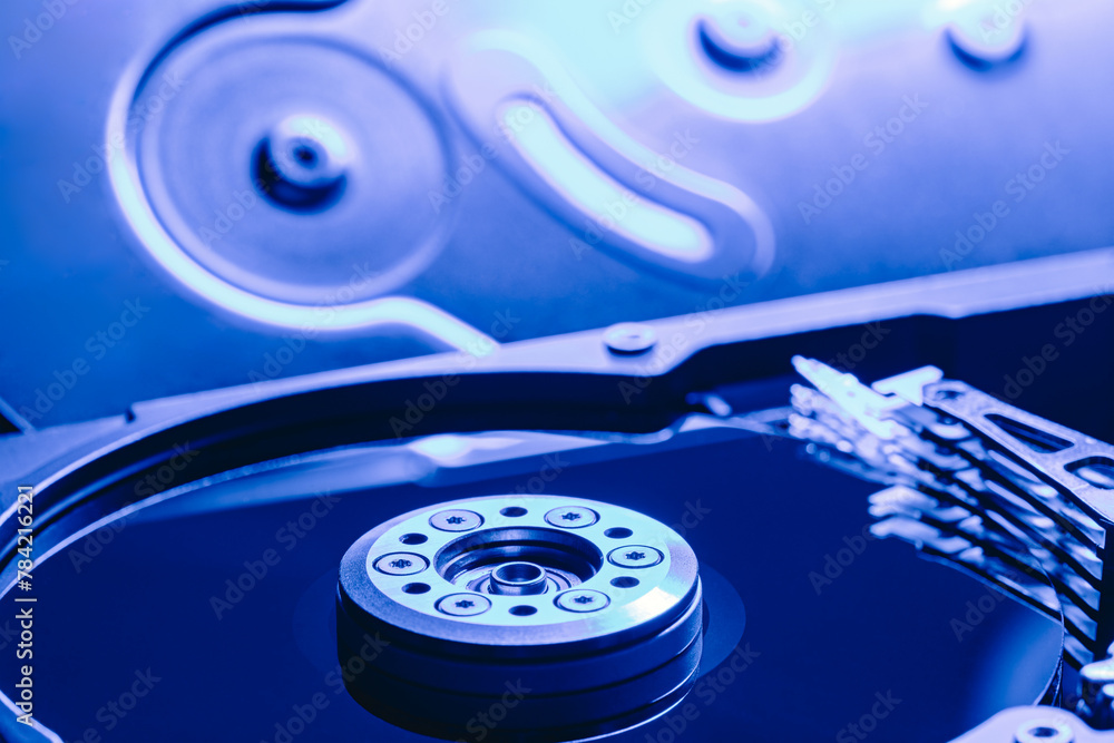 computer hard drive against opened disc cover. blue toned image. computer hard drive against opened disc cover. blue toned image.