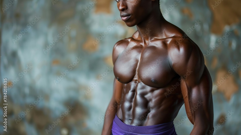 An African American fitness model wears a purple shirt and has clearly defined abdominal muscles.
