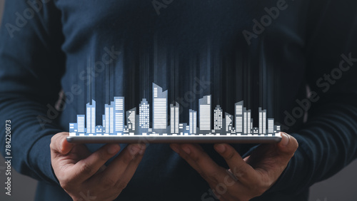 a man hand using digital tablet, and modern buildings hologram. Real estate business and building technology concept. hand holding an empty digital tablet with Smart city with smart services