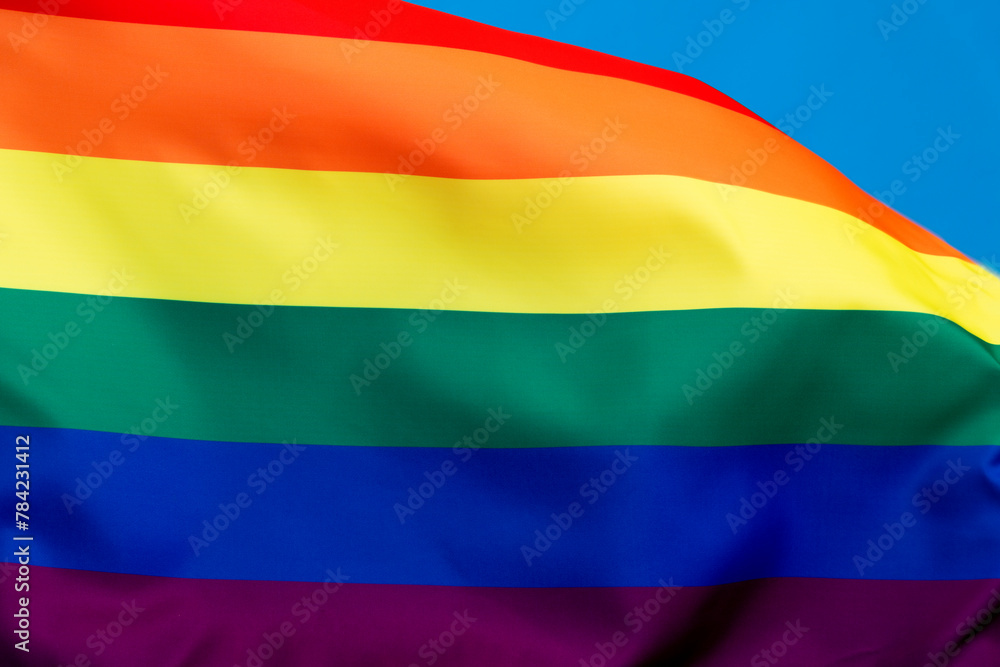 Obraz premium Rainbow flag waving on blue background