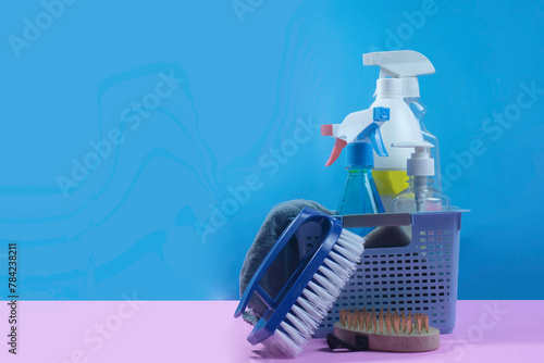 Cleaning equipment and tools are placed on a pink background with a blue background behind.