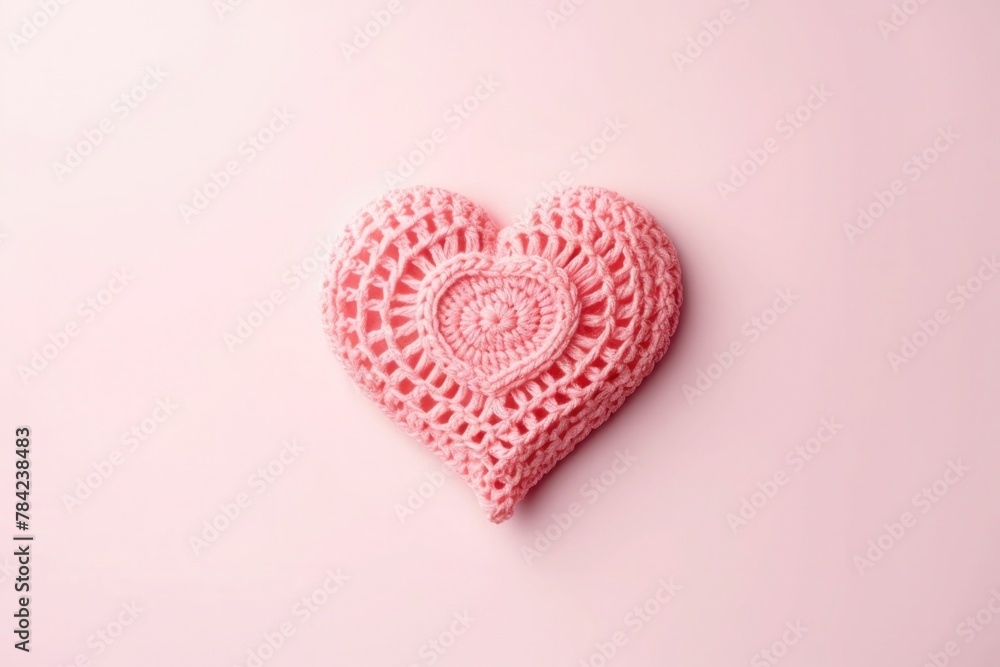 A beautiful crocheted heart with a detailed pattern in soft pink