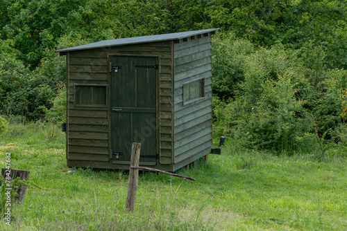 A wooden wildlife photography hide in woodland.