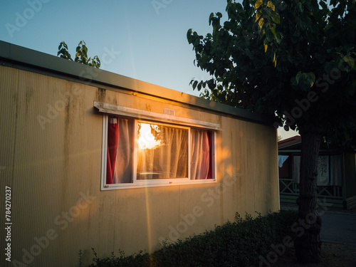 soleil levant dans un bungalow de camping. Mobil home éclairé par le soleil dans un camping en été. Reflets du soleil sur une fenêtre de caravane. image de vacances