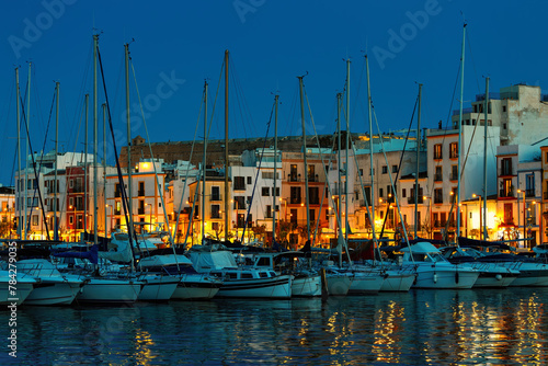 Yachts and illuminated houses in the evening in Ibiza.