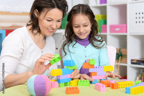 Portrait of cute little girl playing with colorful clay blocks 