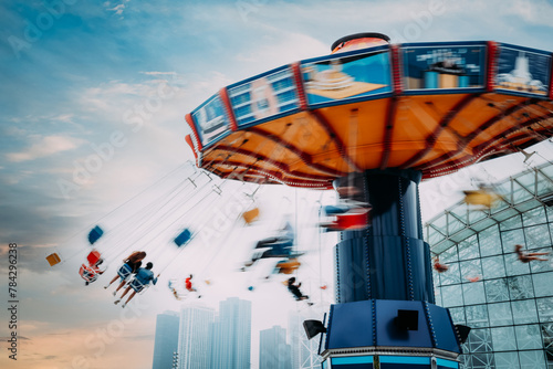 Colorful carnival swing ride with cityscape in background photo