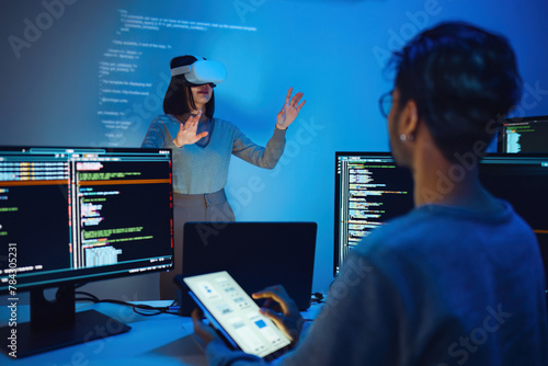 asian and Indian developer devops team testing  virtual reality coding and presentation  with ai prompt  at night in office