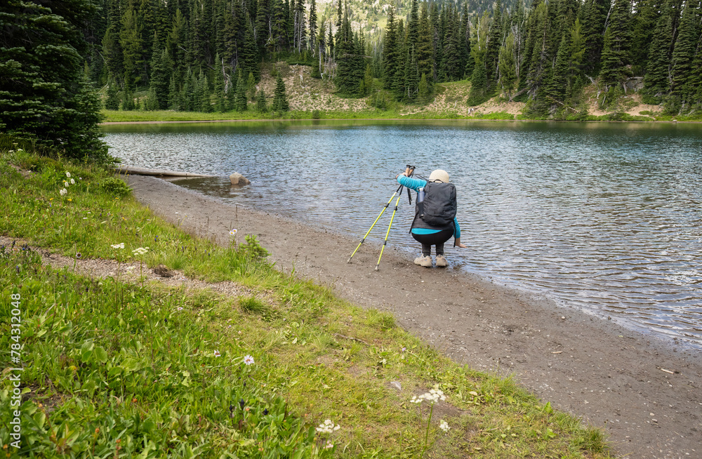 Woman checking water at Shadow Lake. Mount Rainier National Park. Washington State.