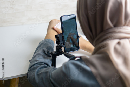 Woman with hijab preparing the recording mobile phone to make a video and produce content
